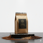 HUX coffee package with scattered coffee beans on a gray surface